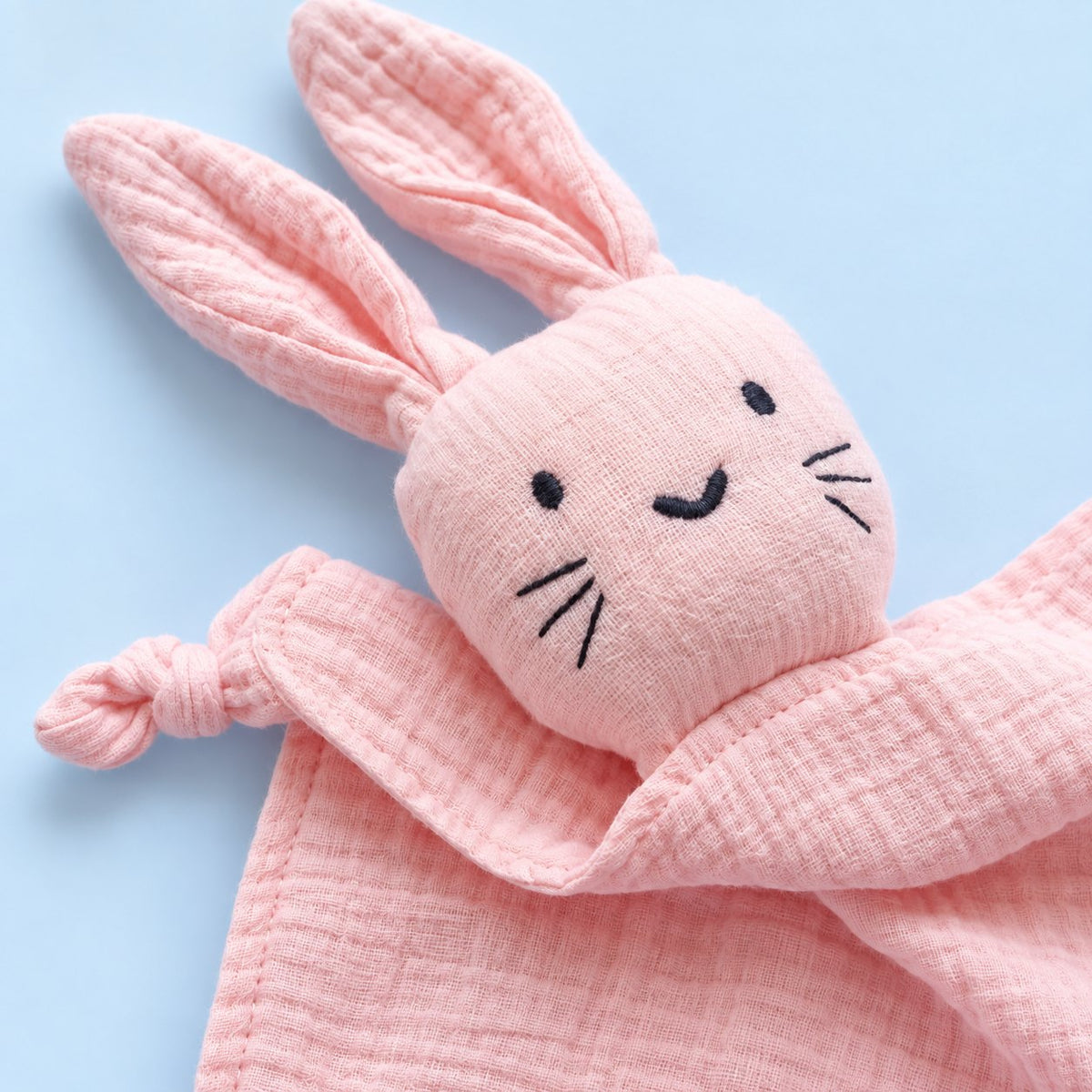 Visage du doudou lapin brodé : yeux, sourire et moustaches cousus
