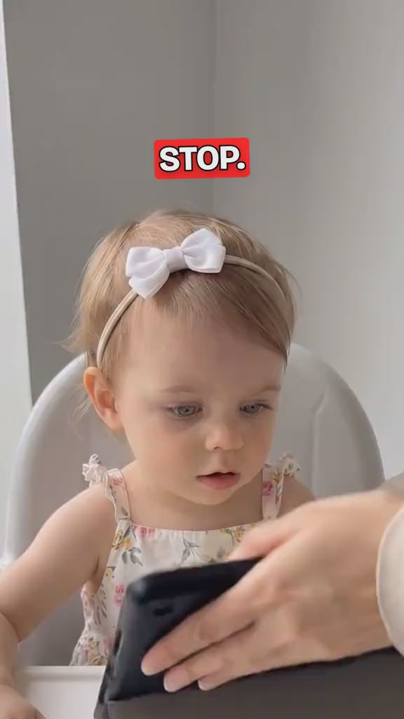 Une petite fille joue avec le livre d’éveil : horloge, boucles, fermetures